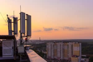 cellular communications tower on background city and beautiful sunset